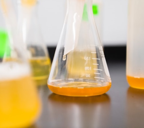 Wissenschaftliches Laborglas mit oranger Substanz